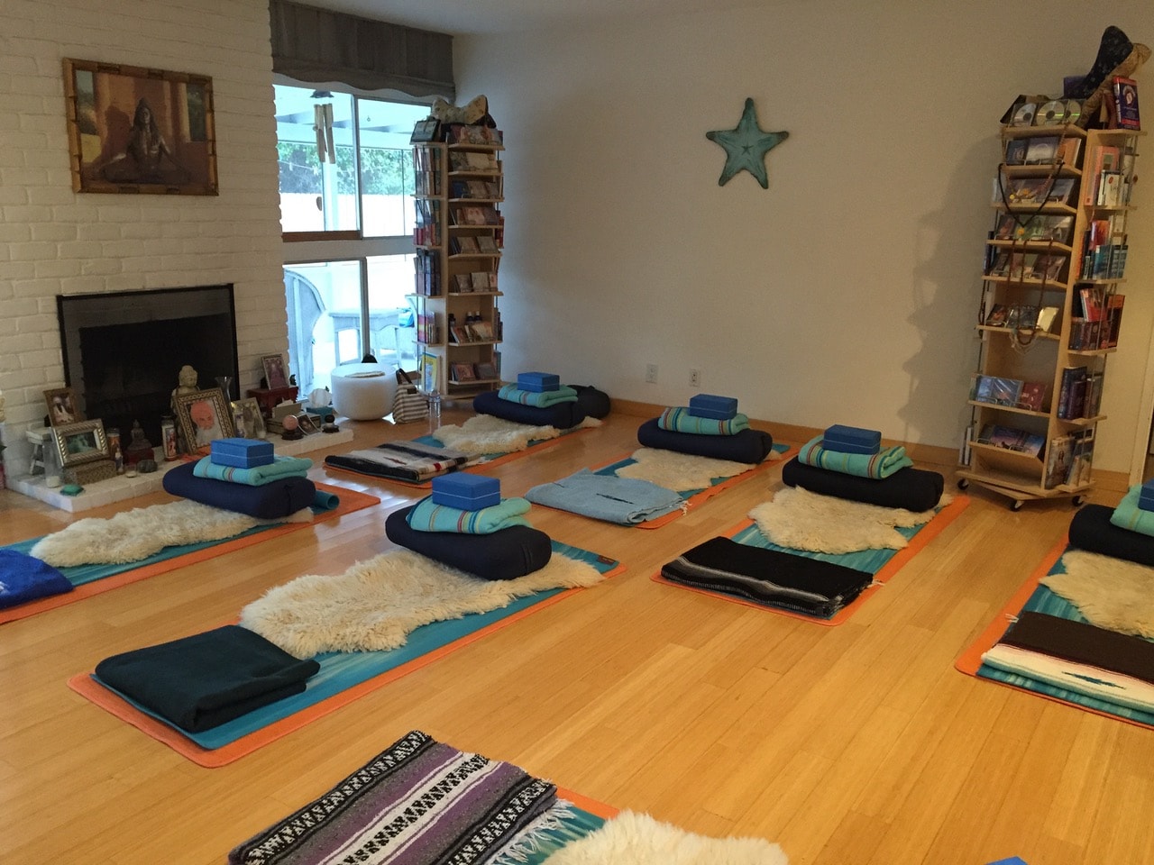 Prepared yoga room with mats, cushions, and blankets